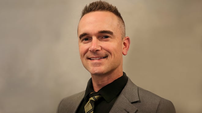 Headshot of Michael Hoehn II, who is a white male wearing a dark brown suit.